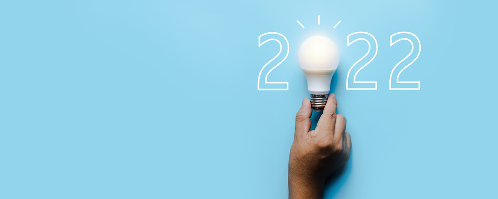 2022: The Year of Illumination. A shining light bulb symbolizes the upcoming year, representing innovation and bright ideas.